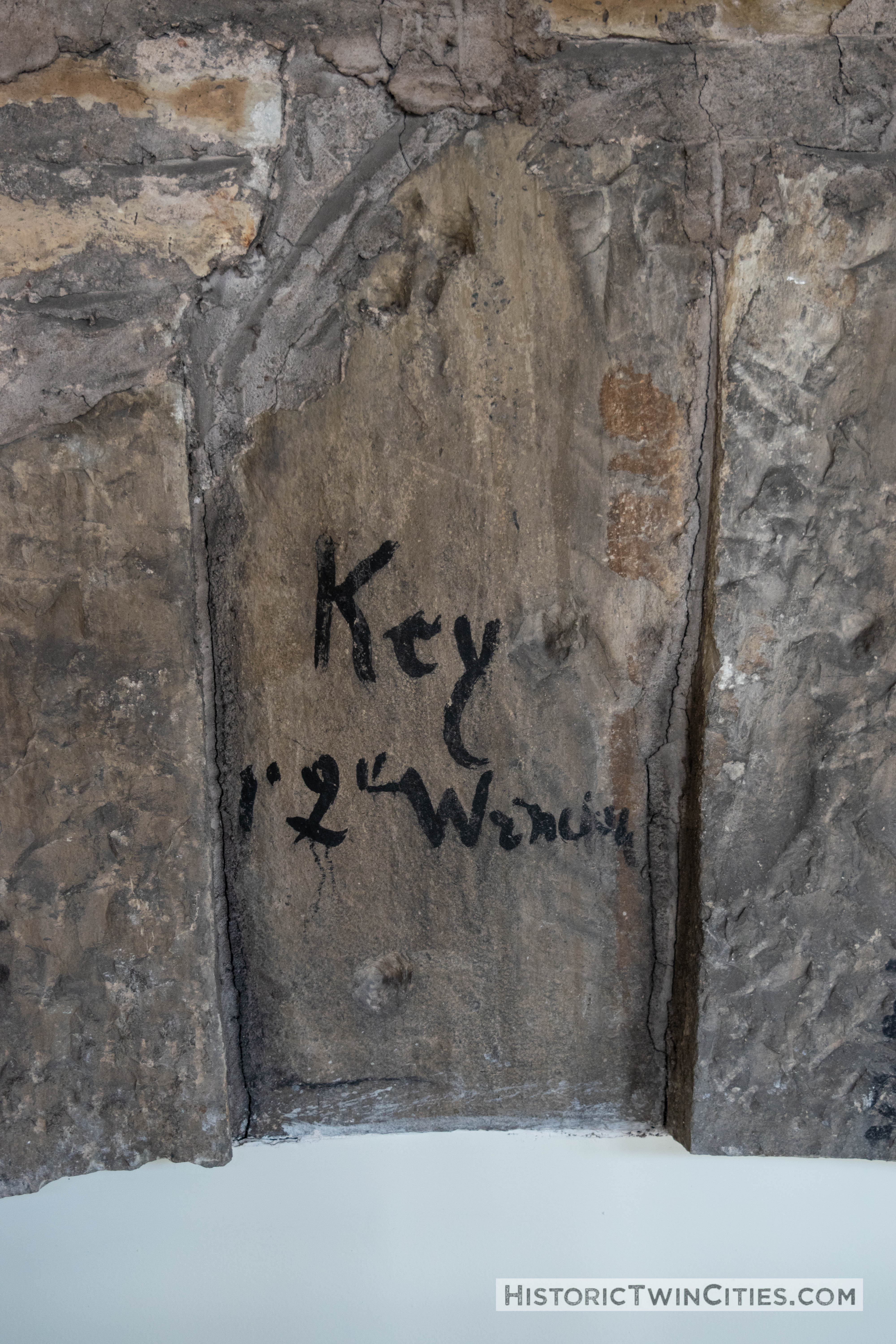 Original keystone at the peak of an arch on the ground level featuring the original quarry markings