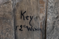 Original keystone at the peak of an arch on the ground level featuring the original quarry markings