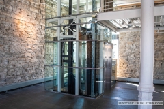 Glass elevator added during the renovation located where on of the original copper brew tanks sat