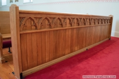 Ornate woodwork on the front row pew in the Historic Church of St. Peter in Mendota